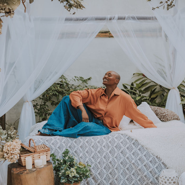 Woman enjoying outdoor space adorned with a decorative mosquito net, creating a stylish and bug-free environment