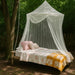Mosquito net set up in a garden, perfect for terraces, balconies, and outdoor lounging areas.
