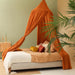 Caramel conical bed canopy hanging over Queen size bed in elegant bedroom