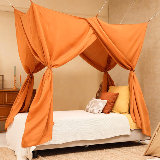 Caramel rectangular bed canopy hanging over single bed in cozy bedroom
