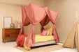 Pink rectangular bed canopy hanging over single bed in elegant bedroom