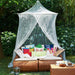 Large mosquito net with wide base offering full coverage for bed or outdoor seating area